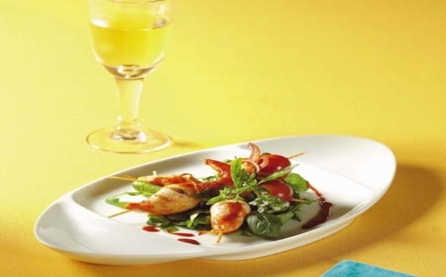 Anticuchos de calamar y langostino en cama de berros